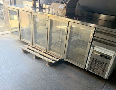 stainless steel counter top with glass doors and a microwave on a pallet