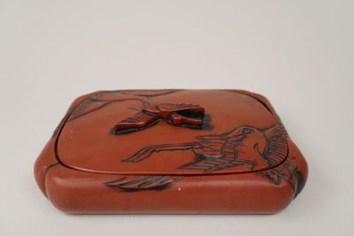 une image représentant une boîte marron ornée d'un motif d'oiseau