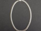 a silver chain necklace on a black surface