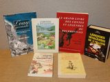 several books are sitting on a table in front of a wall