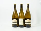 trois bouteilles de vin posées l'une à côté de l'autre sur une table