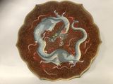 une assiette sur laquelle est représenté un dragon, posée sur une table