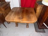 a wooden table and chairs in a room with a red curtain