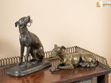 une statue en bronze représentant un chien et un chat posée sur une table