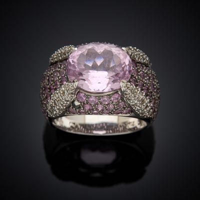 an image of a ring with a pink stone surrounded by pink and white diamonds