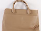 beige leather handbag on a white surface with a white background