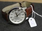 une montre munie d'une étiquette, posée sur une table