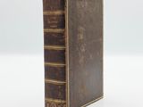 an old book sitting on top of a white surface