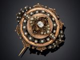 a close up of a broochle with pearls on a black background