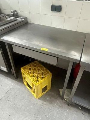 a yellow crate under a stainless steel counter in a kitchen