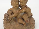 a small statue of a boy and a girl on a plate