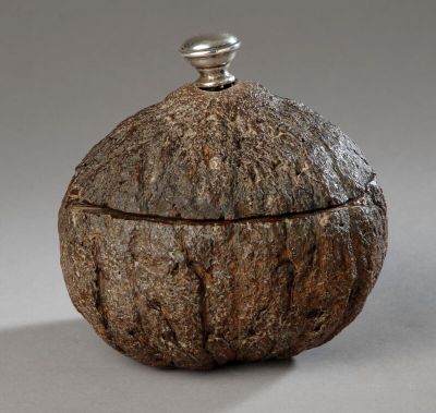 Curieux pot à tabac creusé dans une noix de coco. Le bouton …