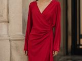 La femme en robe rouge prend la pose devant l'appareil photo.