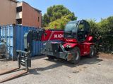 une grue rouge garée à côté d'un conteneur bleu