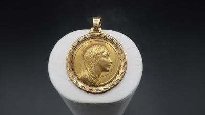 a close up of a gold coin on a white pedestal