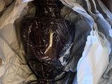 a brown vase sitting in a box with some white paper