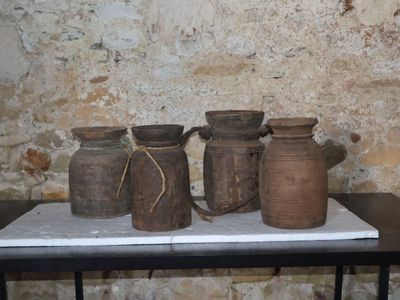 quatre vases posés sur une table devant un mur de briques