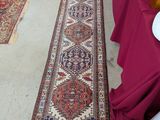 un long tapis posé à même le sol, à côté d'une table sur laquelle sont disposées des assiettes remplies de nourriture