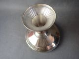 a silver candle holder on a table with a black background