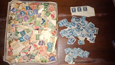 une boîte de timbres et une paire de ciseaux posés sur une table