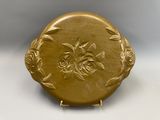 une image représentant une assiette en or ornée de fleurs et de feuilles