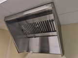 a stainless steel hood mounted on the ceiling of a kitchen