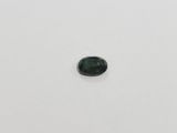 a green tourmaline stone on a white surface