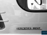 black and white photograph of a mercedes benz logo on the side of a car