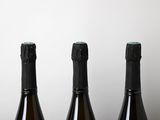 three bottles of wine sitting on top of a table next to each other