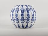 vase en porcelaine bleue et blanche orné de motifs floraux sur fond blanc