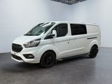 Une camionnette blanche est garée dans une pièce blanche au sol noir.