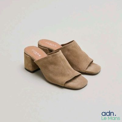 Cette femme porte une paire de mules en daim.