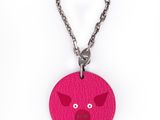 porte-clés en cuir rose avec une tête de cochon suspendue à une chaîne