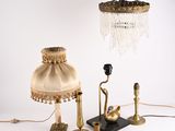 une personne tenant une lampe et un abat-jour posés sur une table