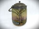 a glass jar with a painting of a tree on it