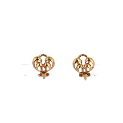 une paire de boucles d'oreilles en or sur fond blanc