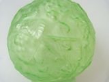 a close up of a green glass object on a white surface