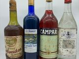 plusieurs bouteilles d'alcool sont alignées sur une surface blanche