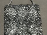 a black and white photo of a beaded purse on a table