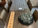 a long table with many glasses on it and a plate of wine glasses on the table