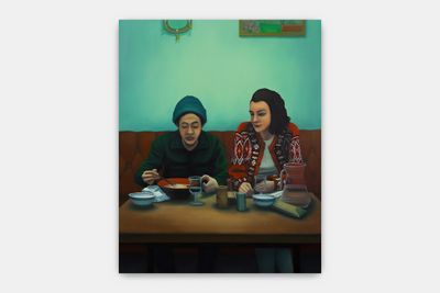 two women sitting at a table with plates of food in front of them