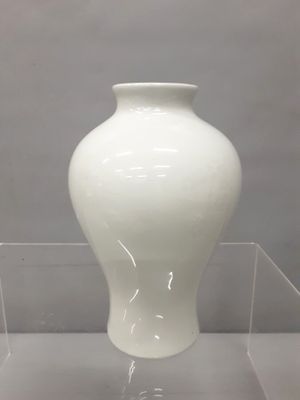 un vase blanc exposé dans une vitrine