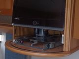une télévision fixée au mur au-dessus du canapé