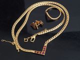 two pieces of jewelry are laying on a black surface