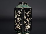 un vase noir et blanc orné de fleurs et d'oiseaux