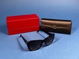 two pairs of sunglasses and a red box on a blue surface