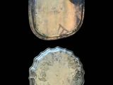 two silver trays sitting next to each other on a black background