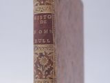 an old book sitting on top of a white surface