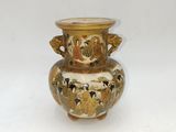 a gold vase with a black and white design on it