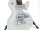 a white guitar that is on a stand on a white background
